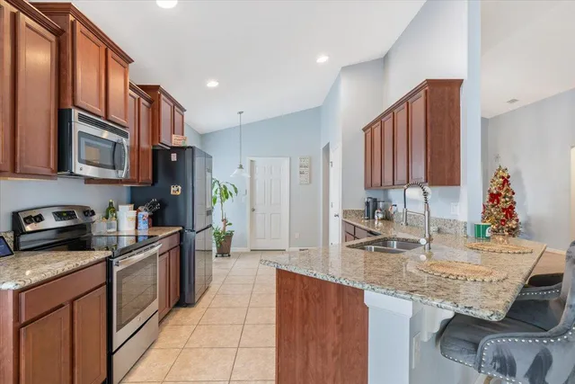 a kitchen with granite countertop a sink stainless steel appliances and cabinets