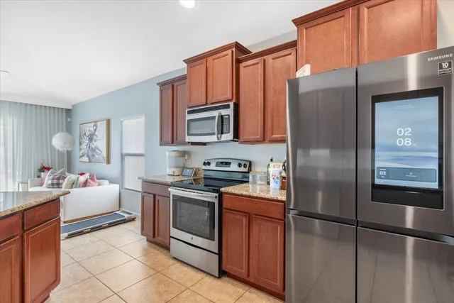 a kitchen with stainless steel appliances granite countertop a refrigerator stove and sink