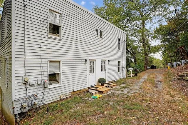 a view of a house with a yard and tree in the background