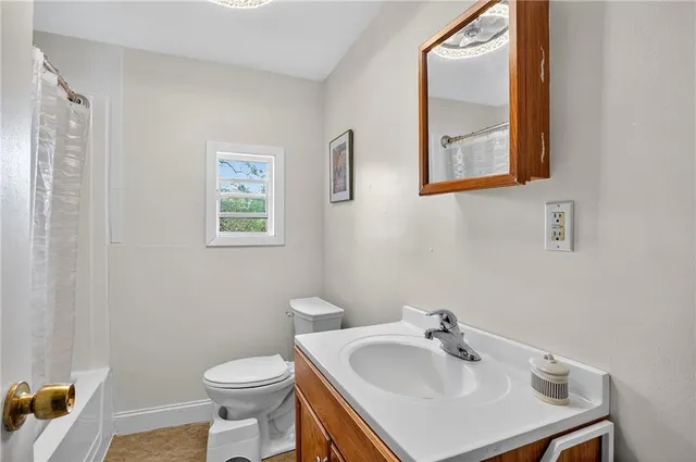 a bathroom with a sink a toilet and mirror