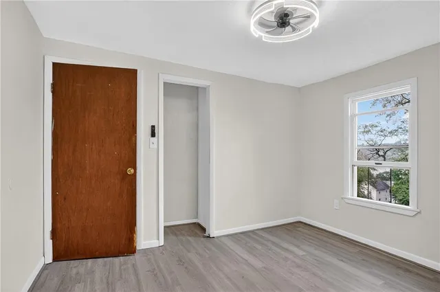 an empty room that has a window and wooden floor