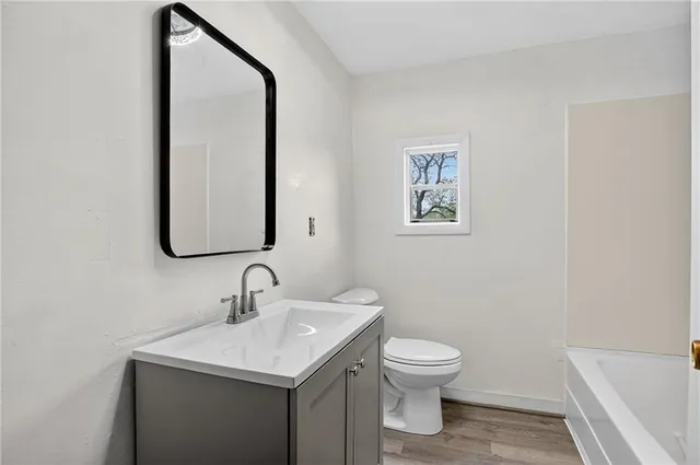 a bathroom with a toilet a sink and mirror