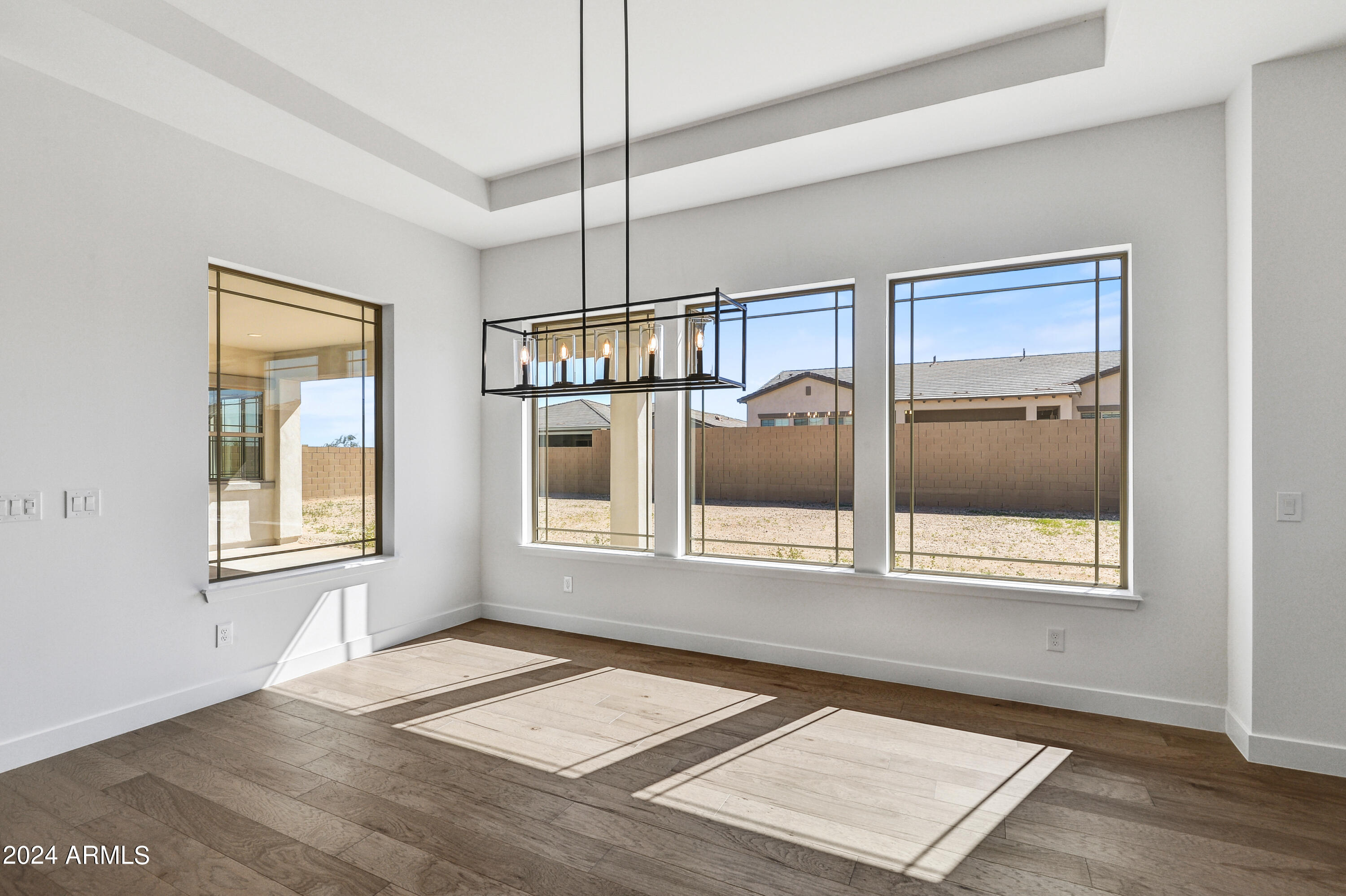 20717 West Rattler Road Buckeye, AZ 85396 - Photo 10 of 30 a view of an empty room with a window and wooden floor