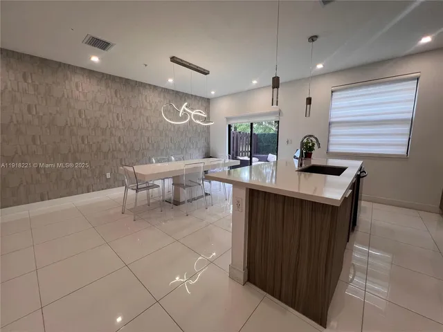 a kitchen with a sink dining table and chairs