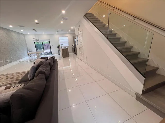a living room with furniture and kitchen view