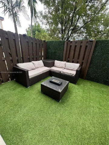 a view of backyard with outdoor seating and green space