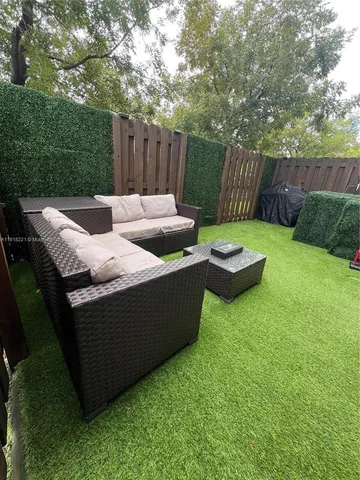 a view of backyard with outdoor seating and green space
