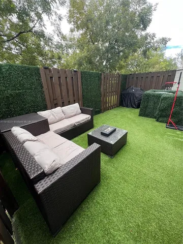 a view of a backyard with furniture and garden