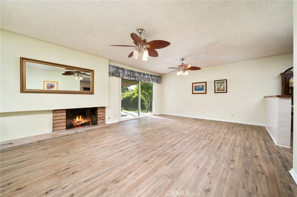 211 Benicia Road Diamond Bar, CA 91765 - Photo 5 of 24 a view of a livingroom with a fireplace a ceiling fan and wooden floor