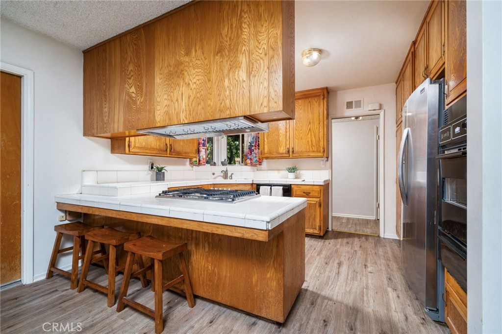 211 Benicia Road Diamond Bar, CA 91765 - Photo 6 of 24 a kitchen with stainless steel appliances a sink a stove a refrigerator and cabinets