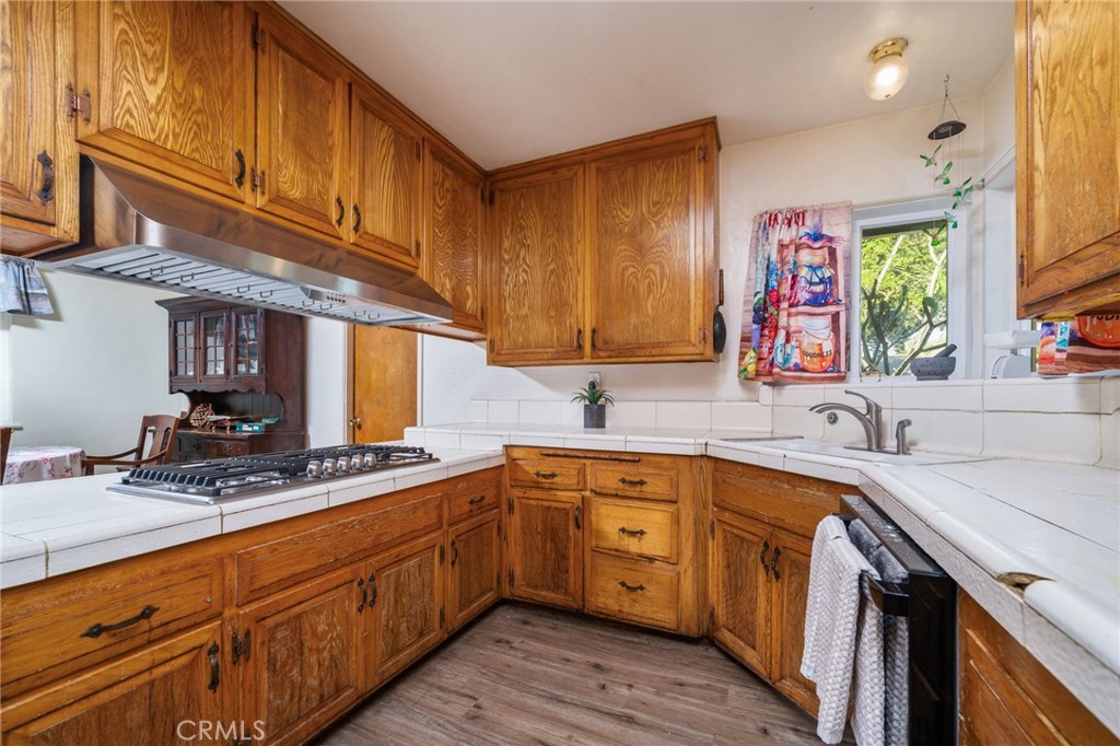 211 Benicia Road Diamond Bar, CA 91765 - Photo 9 of 24 a kitchen with stainless steel appliances granite countertop a sink stove cabinets and wooden floor
