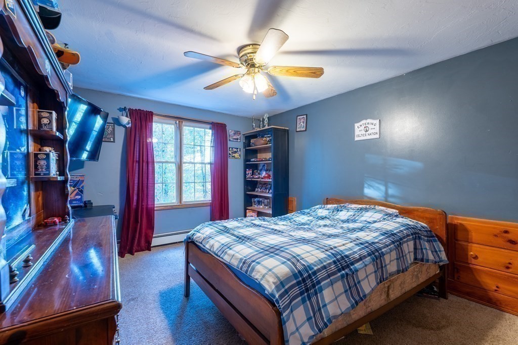 74 Katrina Road Middleboro, MA 02346 - Photo 20 of 37 a bedroom with a bed and a chandelier