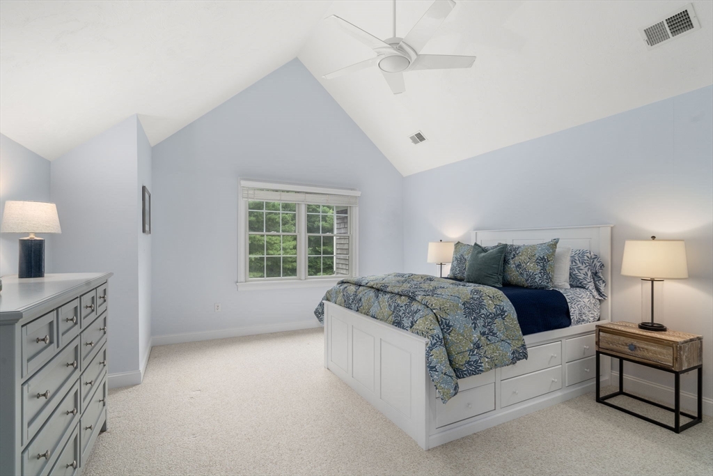 64 Gold Leaf Lane, Unit 64 Mashpee, MA 02649 - Photo 23 of 38 a spacious bedroom with a bed and a lamp
