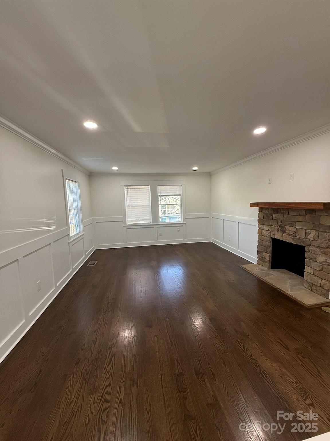 6423 South Tryon Street Charlotte, NC 28217 - Photo 21 of 28 an empty room with wooden floor and fireplace