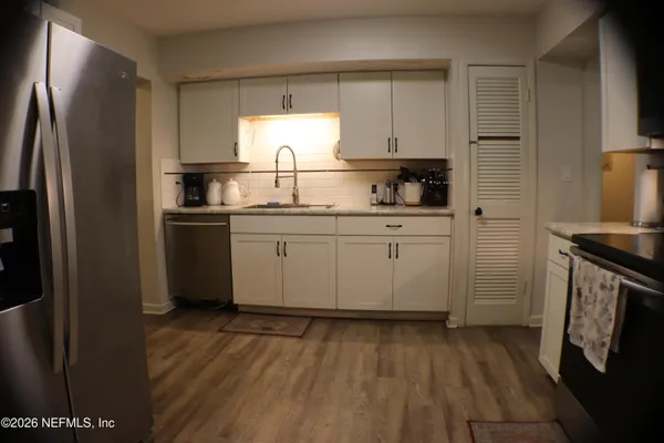 a kitchen with a sink a refrigerator and cabinets