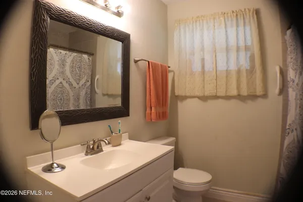 a bathroom with a sink toilet and mirror