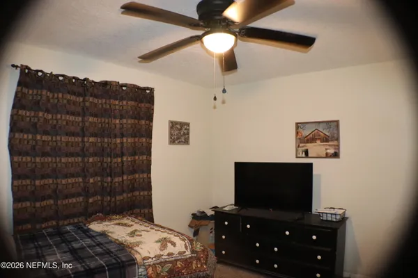 a bedroom with a bed and a flat tv screen on a dresser