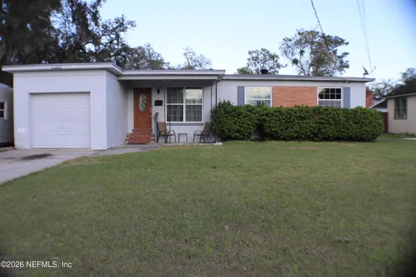 a front view of a house with a garden and yard