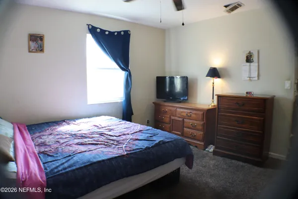 a bedroom with a bed and a flat screen tv