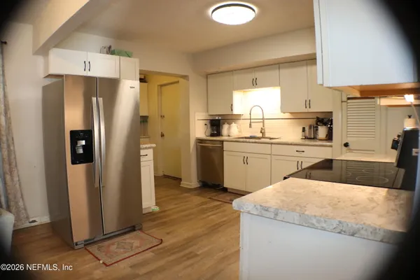 a kitchen with a sink a refrigerator and cabinets