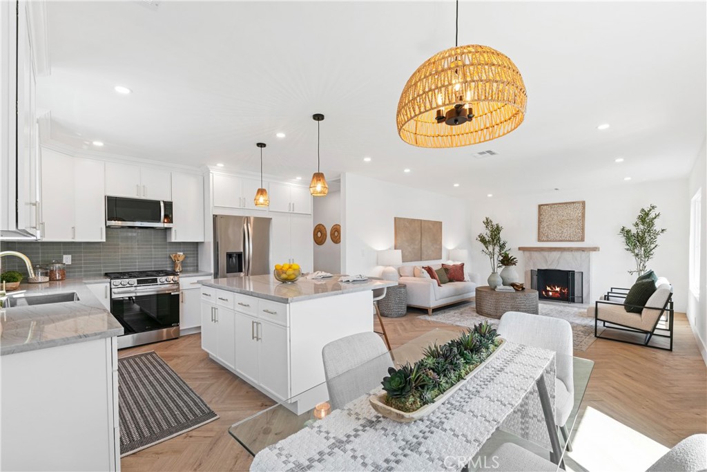 3937 2nd Avenue Los Angeles, CA 90008 - Photo 14 of 47 a kitchen with stainless steel appliances granite countertop a stove a sink dishwasher and white cabinets with wooden floor