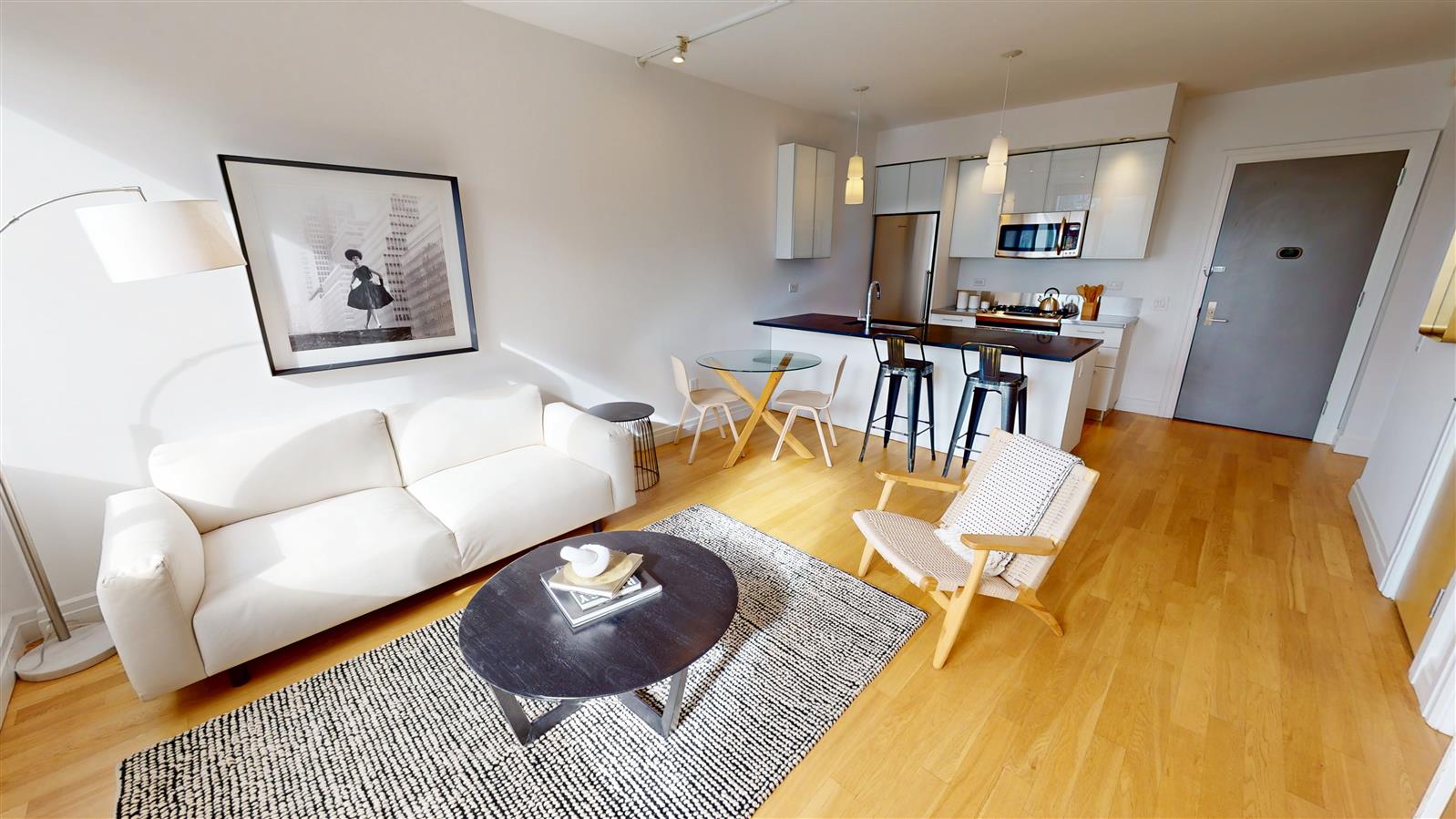 550 West 54th Street, Unit 952 Manhattan, NY 10019 - Photo 2 of 27 a living room with furniture and a table