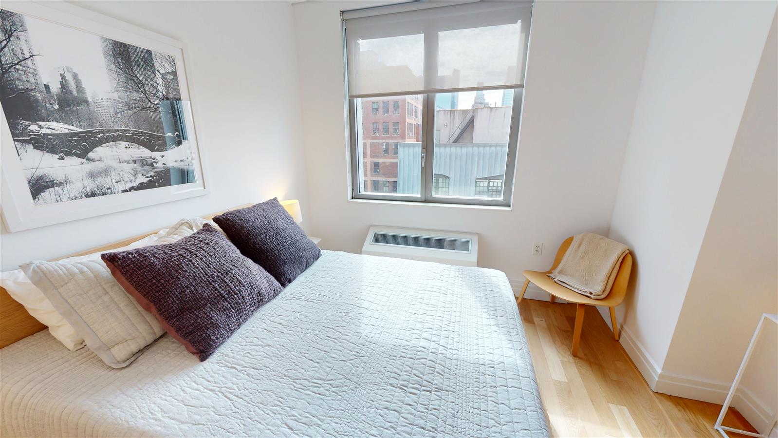 550 West 54th Street, Unit 952 Manhattan, NY 10019 - Photo 3 of 27 a bedroom with a bed and wooden floor