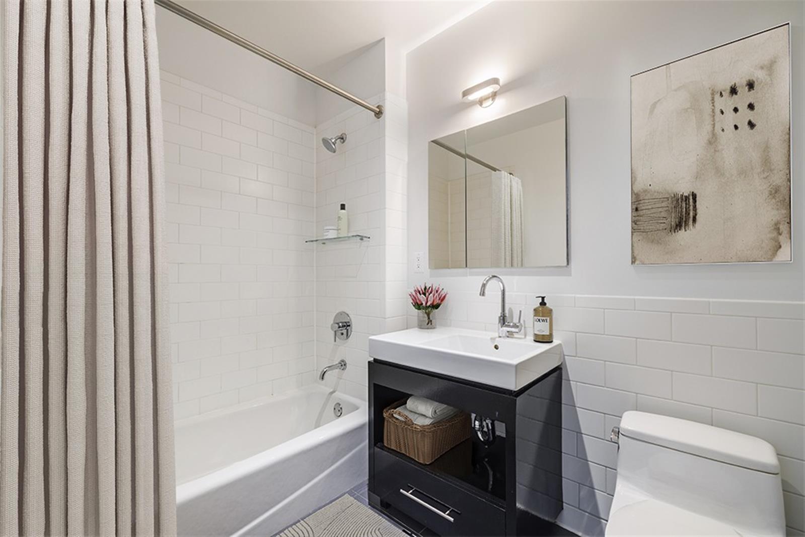 550 West 54th Street, Unit 952 Manhattan, NY 10019 - Photo 5 of 27 a bathroom with a sink toilet and vanity