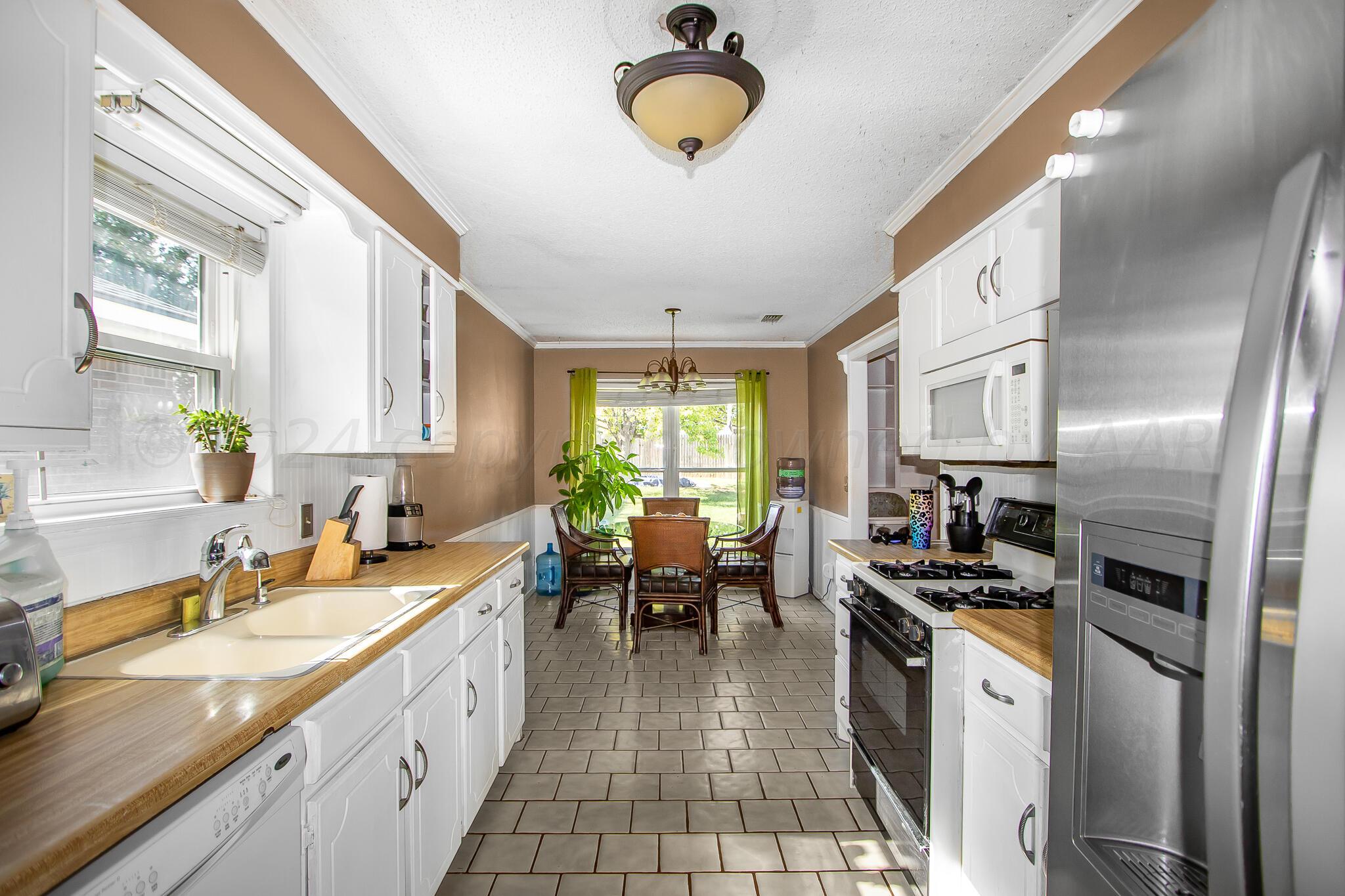 2208 Gresham Drive Amarillo, TX 79110 - Photo 12 of 31 a kitchen with stainless steel appliances granite countertop a sink stove and refrigerator