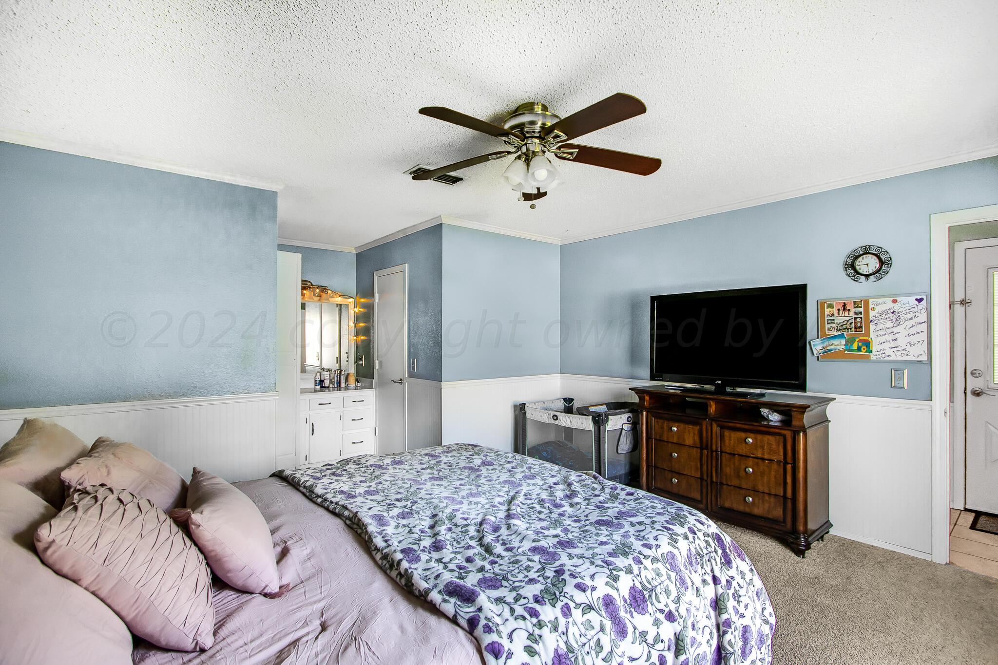 2208 Gresham Drive Amarillo, TX 79110 - Photo 14 of 31 a bedroom with a bed and a flat screen tv