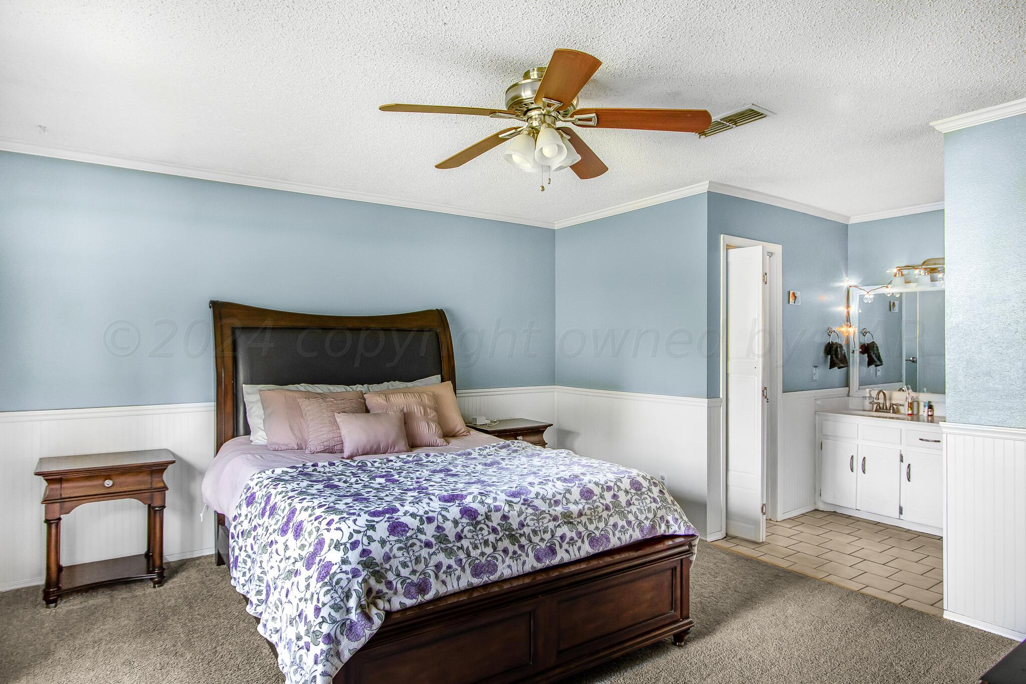 2208 Gresham Drive Amarillo, TX 79110 - Photo 16 of 31 a bedroom with a large bed and a chandelier
