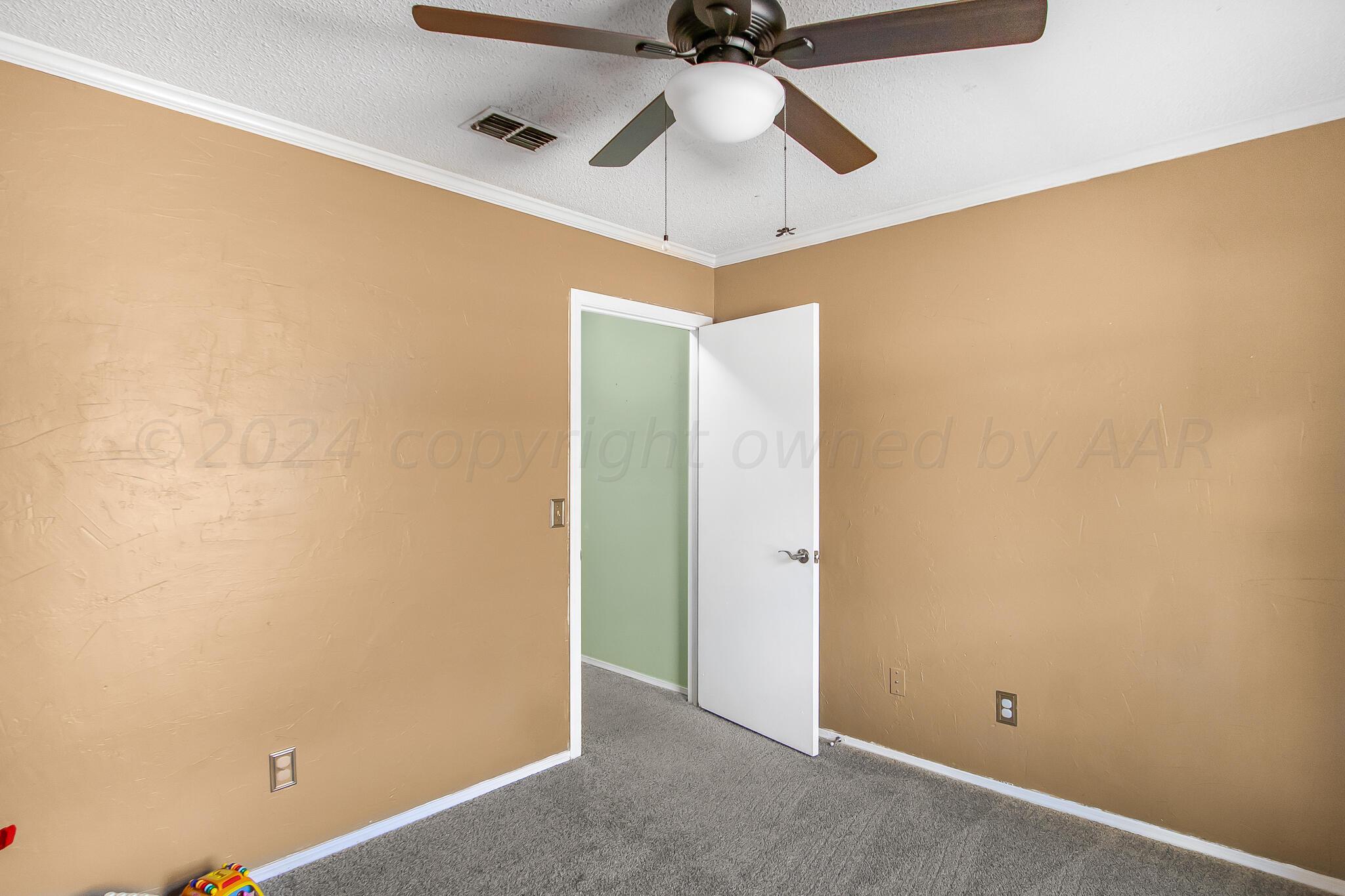 2208 Gresham Drive Amarillo, TX 79110 - Photo 23 of 31 an empty room with a ceiling fan and closet