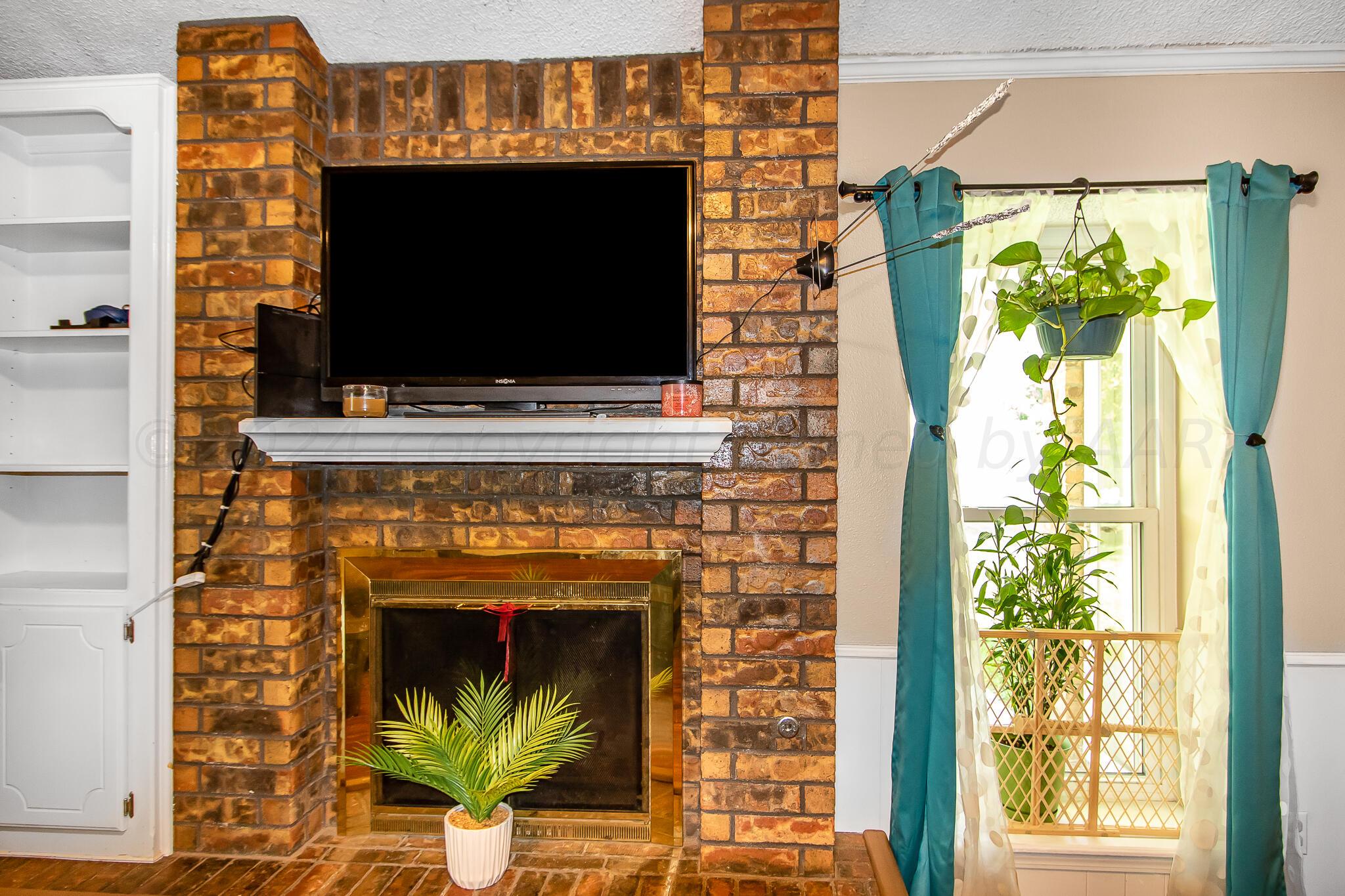 2208 Gresham Drive Amarillo, TX 79110 - Photo 9 of 31 a living room with a fireplace and a flat screen tv