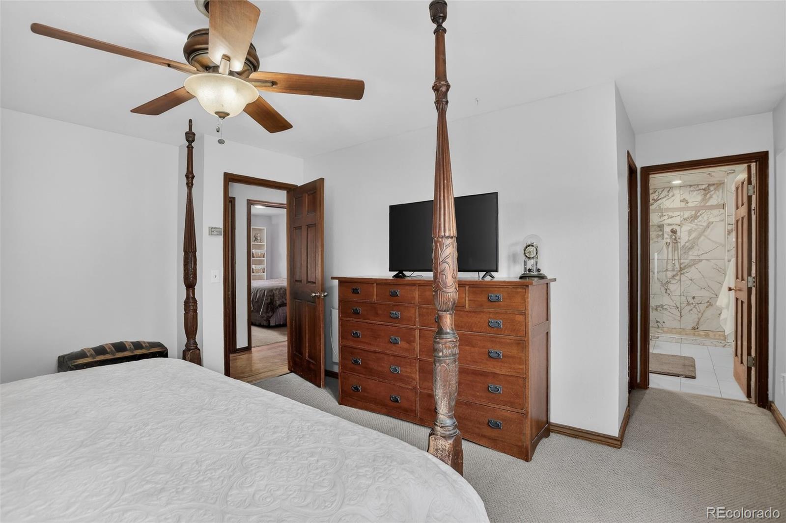 12699 South Foxton Road Conifer, CO 80433 - Photo 15 of 40 a bedroom with a bed and a flat tv screen on a dresser