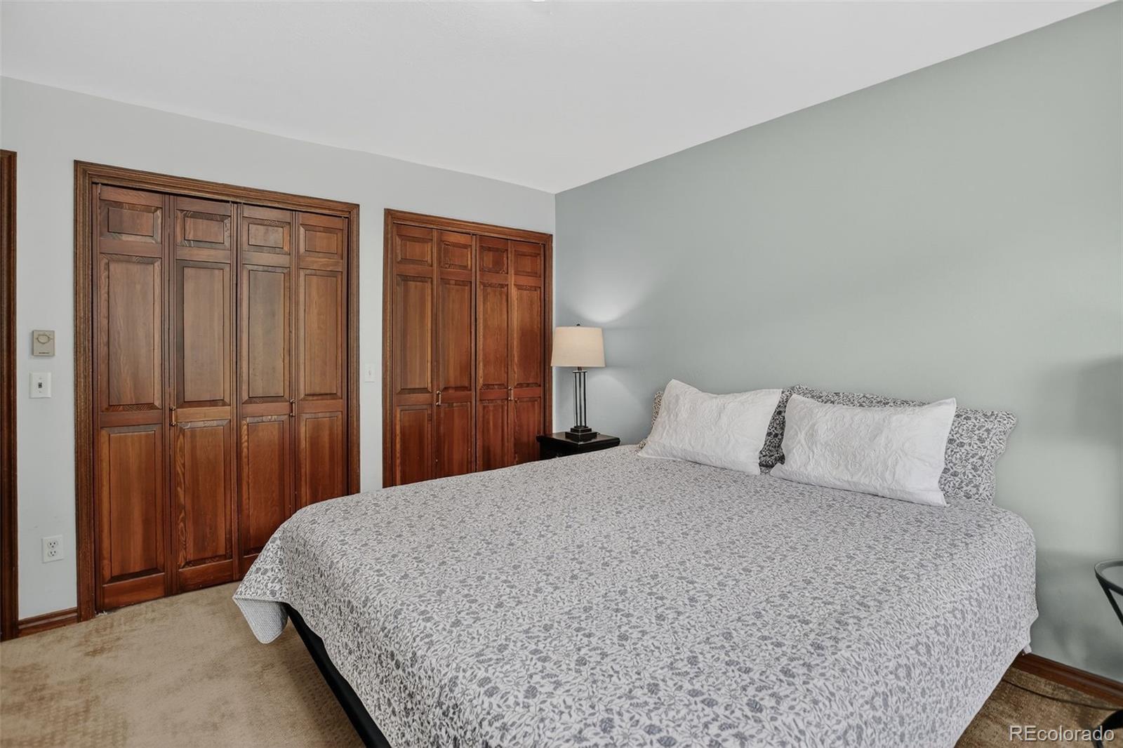 12699 South Foxton Road Conifer, CO 80433 - Photo 19 of 40 a bedroom with a large bed and wooden floor