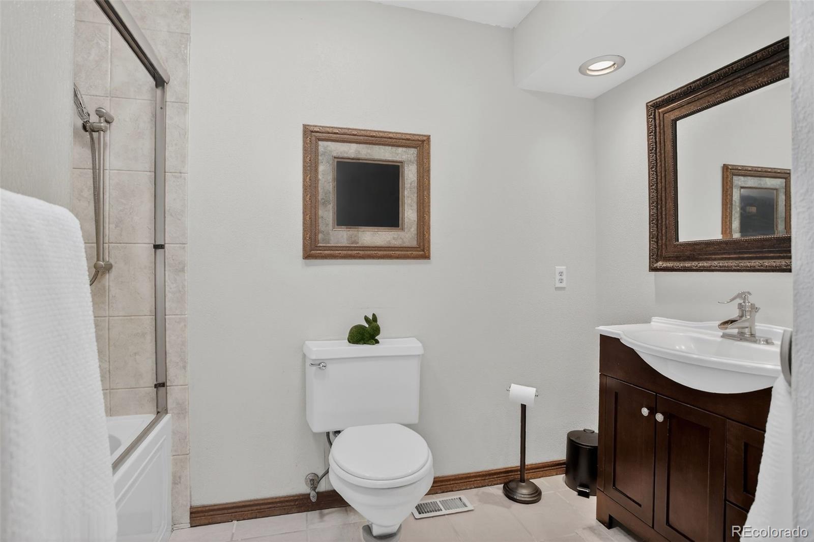 12699 South Foxton Road Conifer, CO 80433 - Photo 20 of 40 a bathroom with a toilet sink vanity and mirror