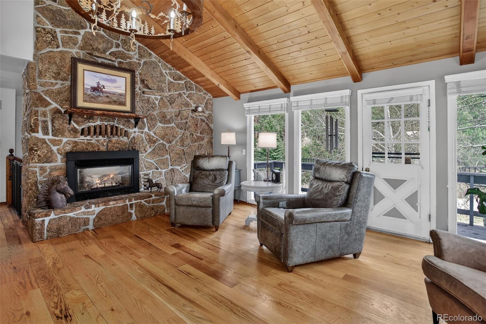 12699 South Foxton Road Conifer, CO 80433 - Photo 2 of 40 a living room with furniture and a fireplace