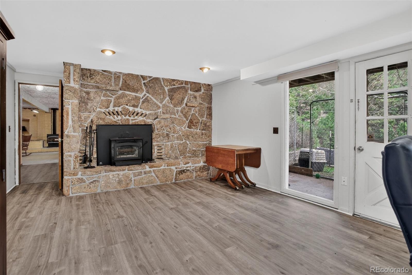12699 South Foxton Road Conifer, CO 80433 - Photo 21 of 40 a living room with furniture and a fireplace