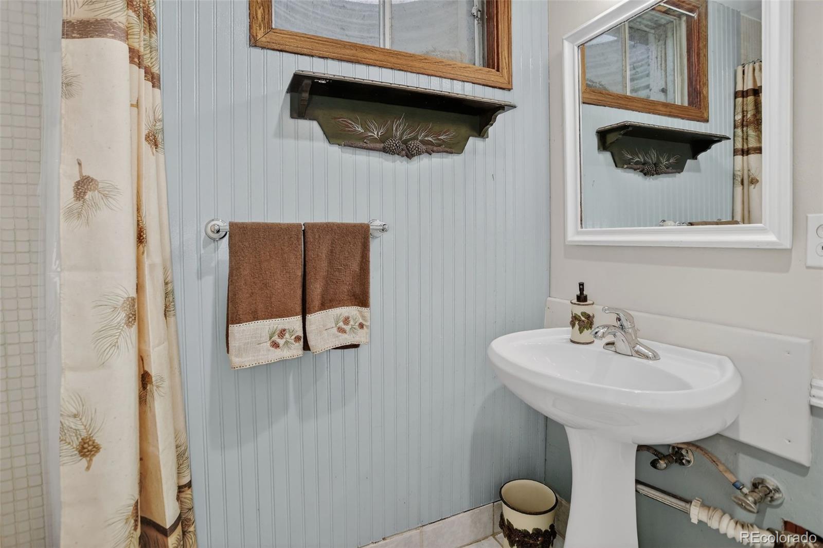 12699 South Foxton Road Conifer, CO 80433 - Photo 25 of 40 a bathroom with a sink a toilet and mirror