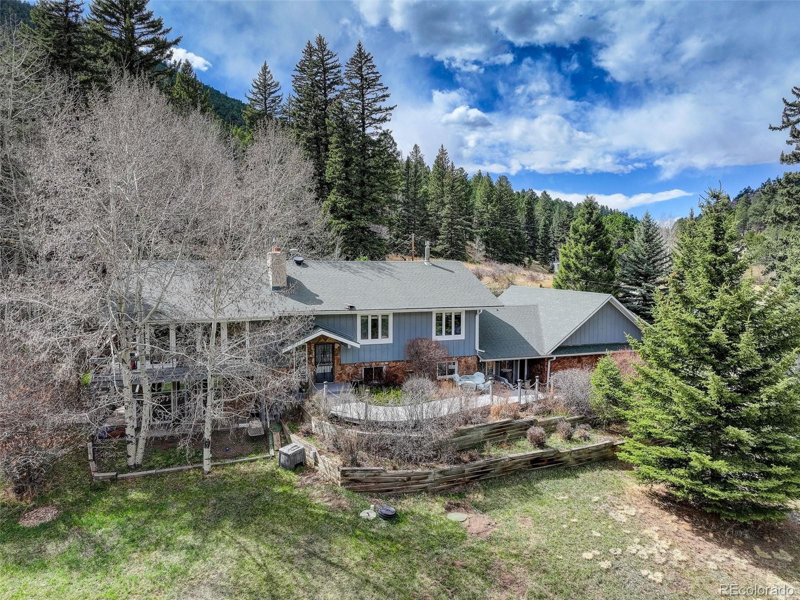 12699 South Foxton Road Conifer, CO 80433 - Photo 40 of 40 a aerial view of a house with a yard table and chairs