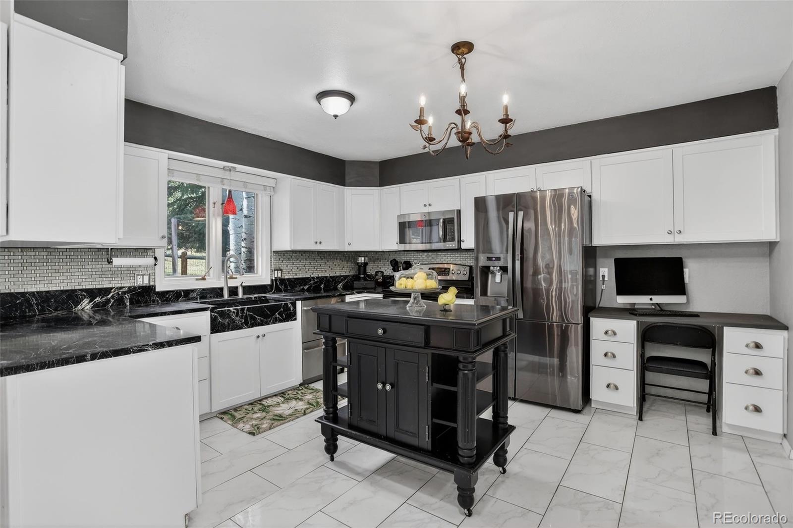 12699 South Foxton Road Conifer, CO 80433 - Photo 8 of 40 a kitchen with a refrigerator a microwave a stove and cabinets