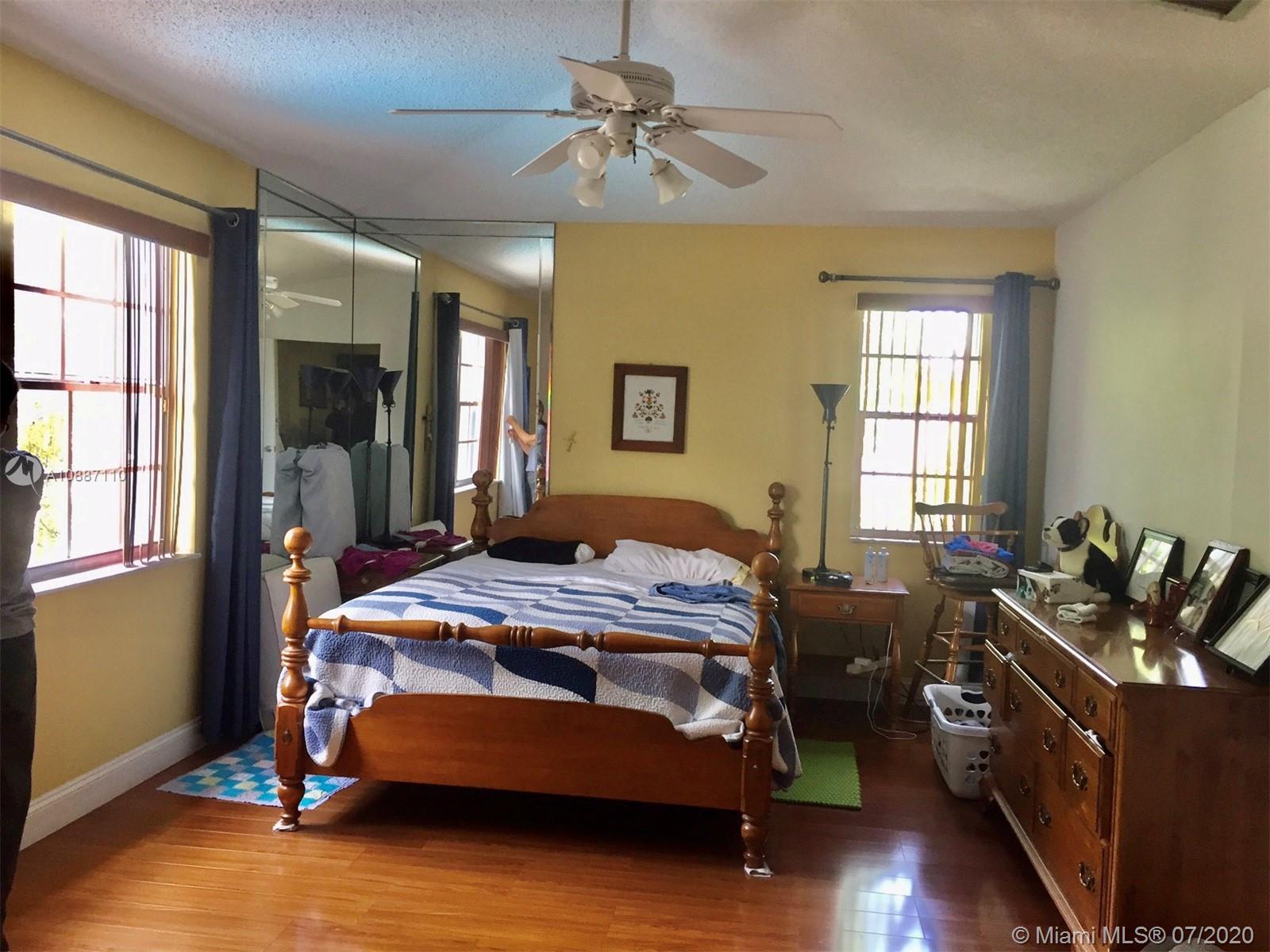 6345 Southwest 138th Court, Unit 110 Miami, FL 33183 - Photo 12 of 13 a bedroom with a bed and wooden floors