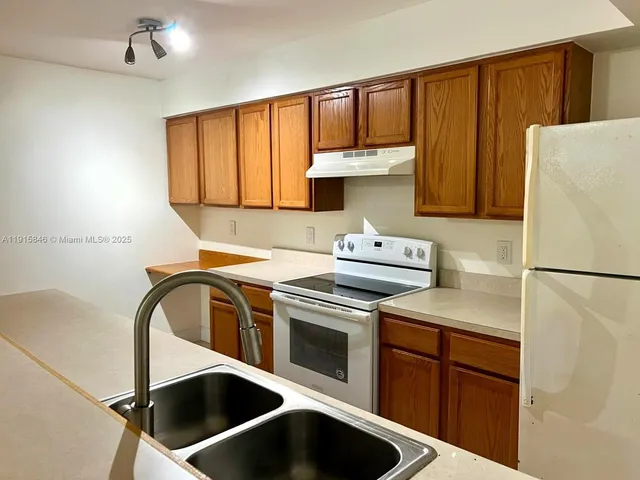 a kitchen with a refrigerator sink and cabinets