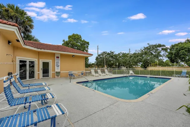 a view of a house with swimming pool and sitting area