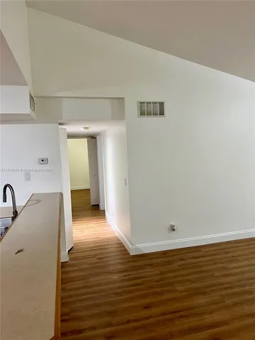 a view of a room with wooden floor