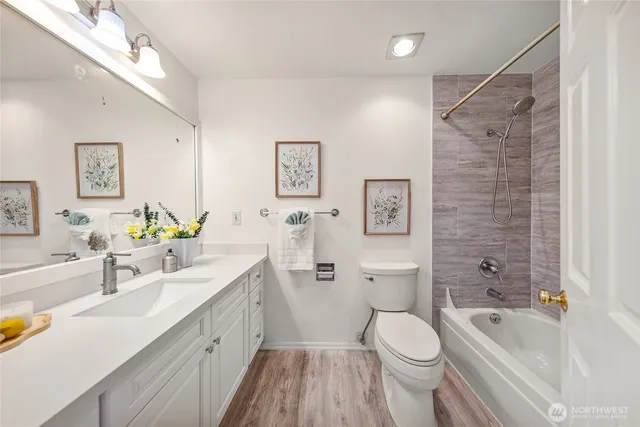 a bathroom with a sink a toilet and shower