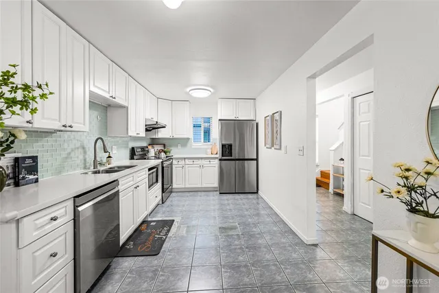 a kitchen with stainless steel appliances granite countertop a refrigerator sink and cabinets