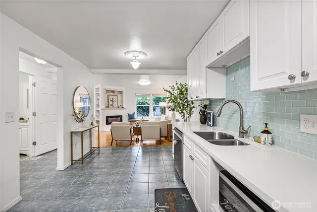 a view of living room with stainless steel appliances furniture a rug kitchen view and living room