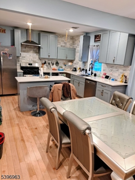 149 Smith Street Newark, NJ 07106 - Photo 19 of 20 a kitchen with stainless steel appliances kitchen island granite countertop a table chairs sink and cabinets