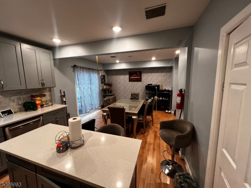 149 Smith Street Newark, NJ 07106 - Photo 5 of 20 a kitchen with stainless steel appliances wooden floor dining table and chairs